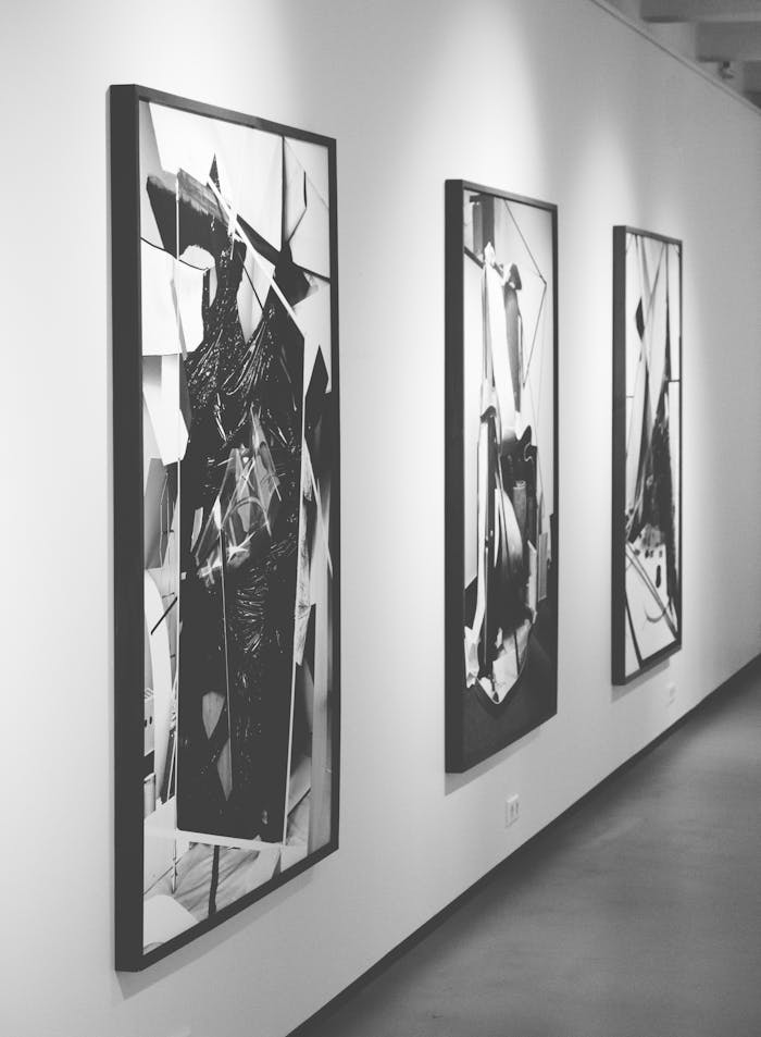 hero-img-02 Monochrome abstract paintings on display in a modern art gallery.